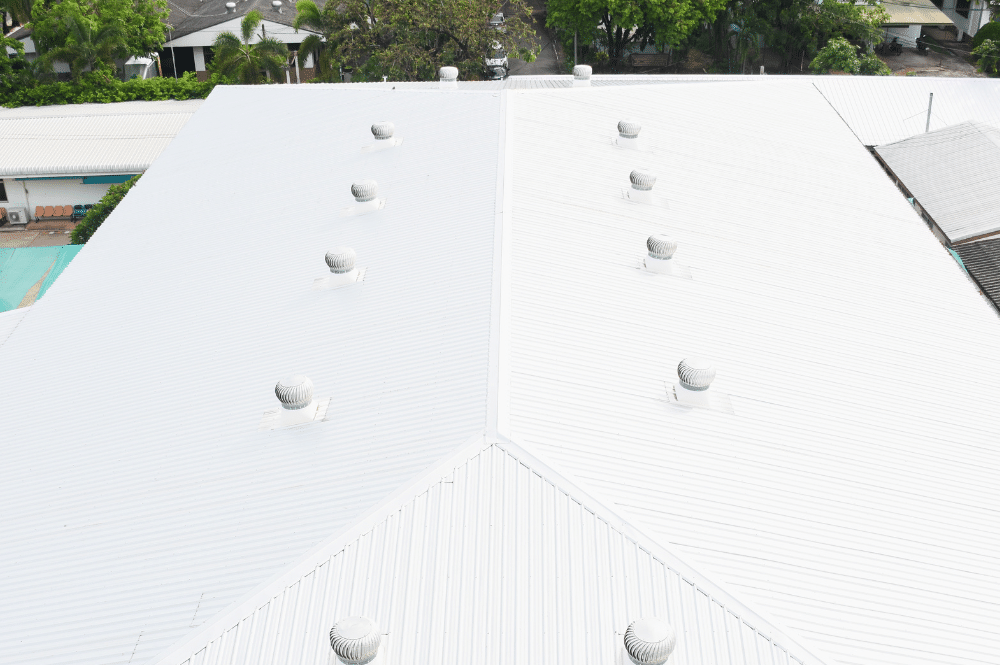 White low-slope commercial roof with several rooftop penetrations