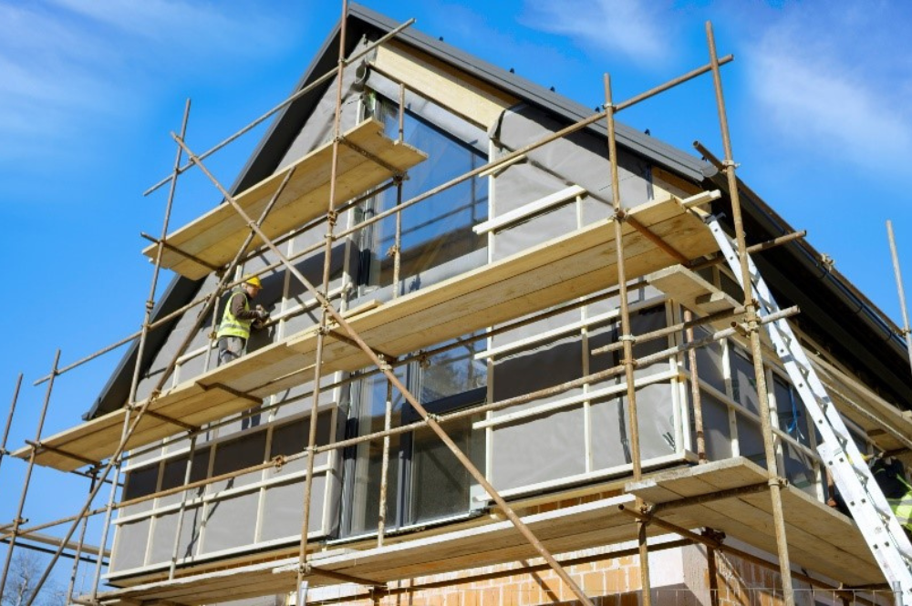 A house under construction, showcasing ongoing home improvements with building materials visible.