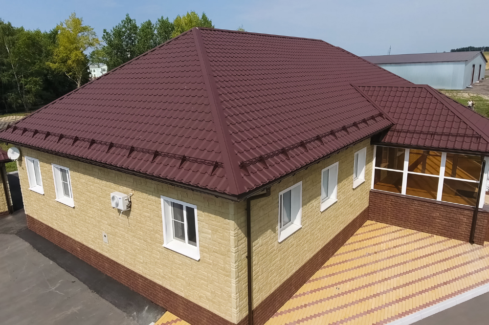 A house featuring a dark red roof, reflecting current residential roofing trends in design aesthetics.