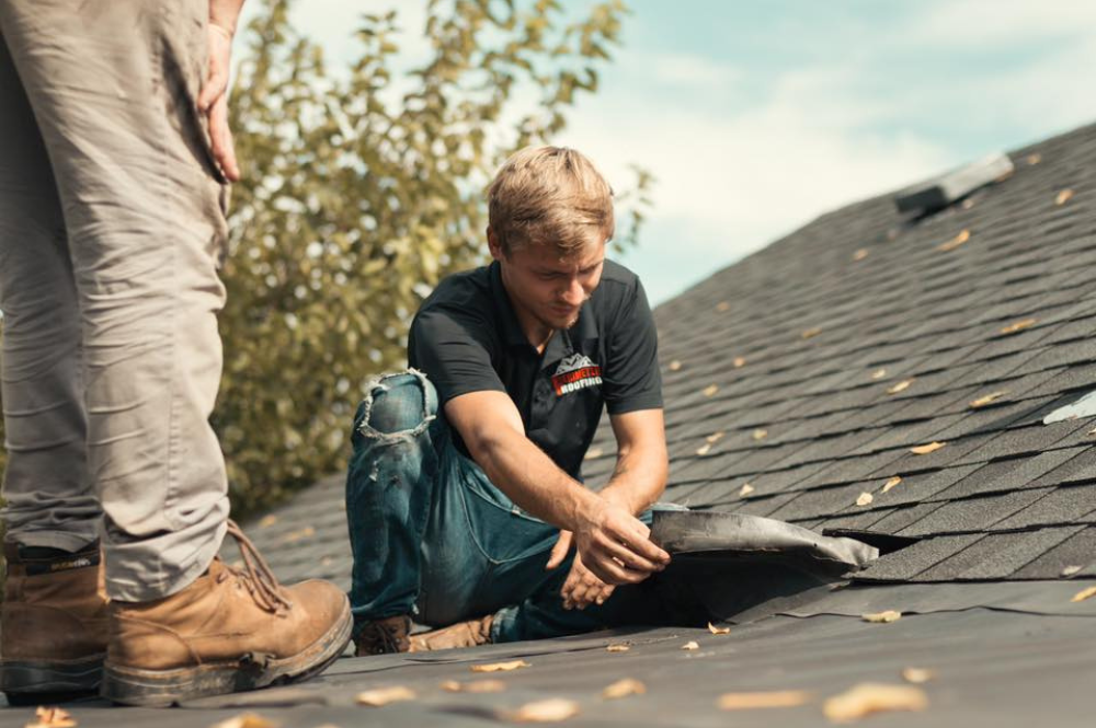 Two men performing roof leak repairs to ensure a secure and weatherproof structure.