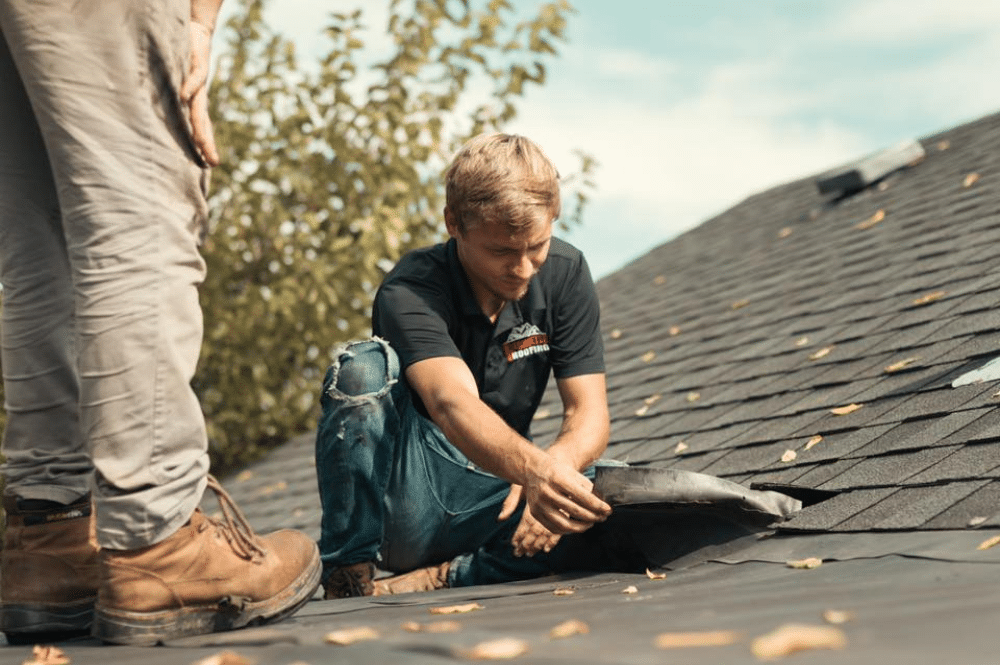 Roof Leaks Repair_1 Two men performing roof leak repairs to ensure a secure and weatherproof structure.